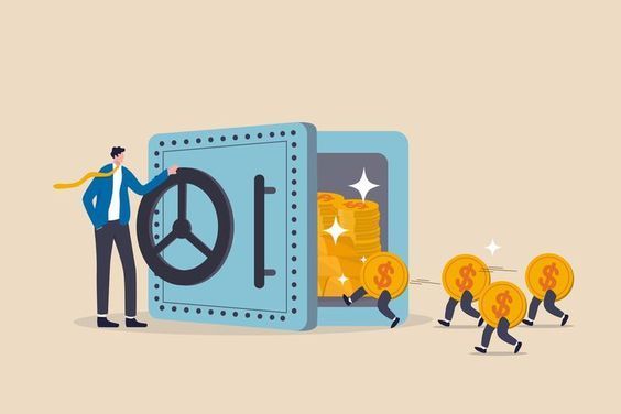A man is standing next to a safe filled with money.